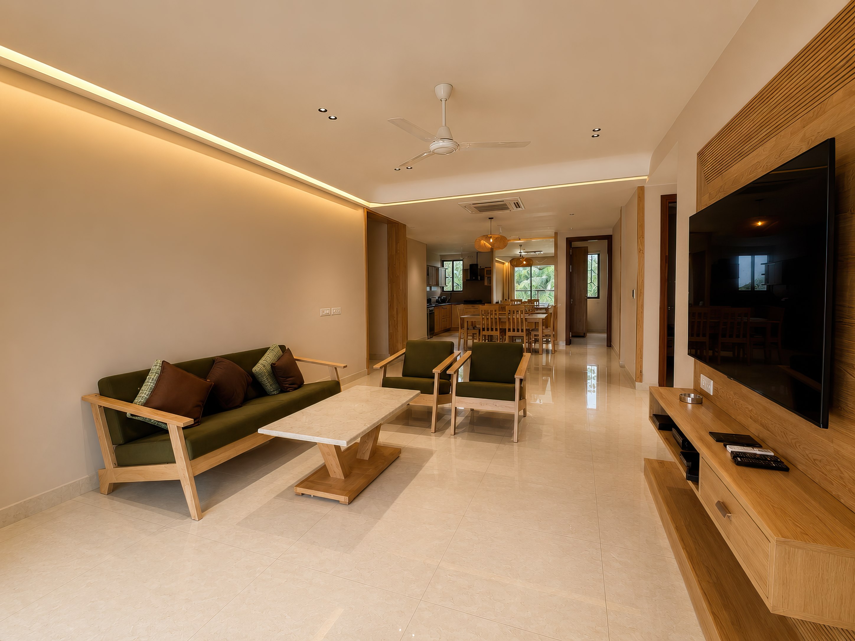 Living room with a sofa and TV, opening through to the dining area and kitchen